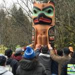 A crowd gathers around a totem pole carved by Alison Marks, a Tlingit artist. The pole was raised Tuesday, Oct. 27 in Yakutat near Marks grandfathers house. (Courtesy Photo | Thom Landgreen)