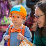 Leah Heiman watches her son, Evan, 2, as they visit downtown merchants for Halloween on Wednesday, Oct. 31, 2018. For the fourth year Kindred Post has organized the Halloween celebration for trick-or-treaters. (Michael Penn | Juneau Empire)