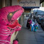 A T-Rex awaits Laura Cooper and her twins, Tanner and Amara, 5, in front of the Imagination Station on Wednesday, Oct. 31, 2018. For the fourth year Kindred Post has organized the Halloween celebration for trick-or-treaters. (Michael Penn | Juneau Empire)