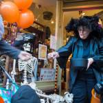 Suzanne Hudson, owner of Nanas Attic, hands out candy to visiting children and their parents on Wednesday, Oct. 31, 2018. For the fourth year Kindred Post has organized the Halloween celebration for trick-or-treaters. (Michael Penn | Juneau Empire)