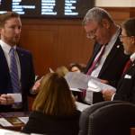 Rep. Jason Grenn, I-Anchorage (left) speaks to Rep. Dan Saddler, R-Eagle River (standing center), Rep. George Rauscher, R-Sutton (standing right) and Rep. Lora Reinbold, R-Eagle River (seated) before the final vote Friday, May 11, 2018 on House Bill 44. (Brian Hild | Alaska House Majority)                                Rep. Jason Grenn, I-Anchorage (left) speaks to Rep. Dan Saddler, R-Eagle River (standing center), Rep. George Rauscher, R-Sutton (standing right) and Rep. Lora Reinbold, R-Eagle River (seated) on Friday, May 11, 2018 in the Alaska House of Representatives. (Brian Hild | Alaska House Majority)