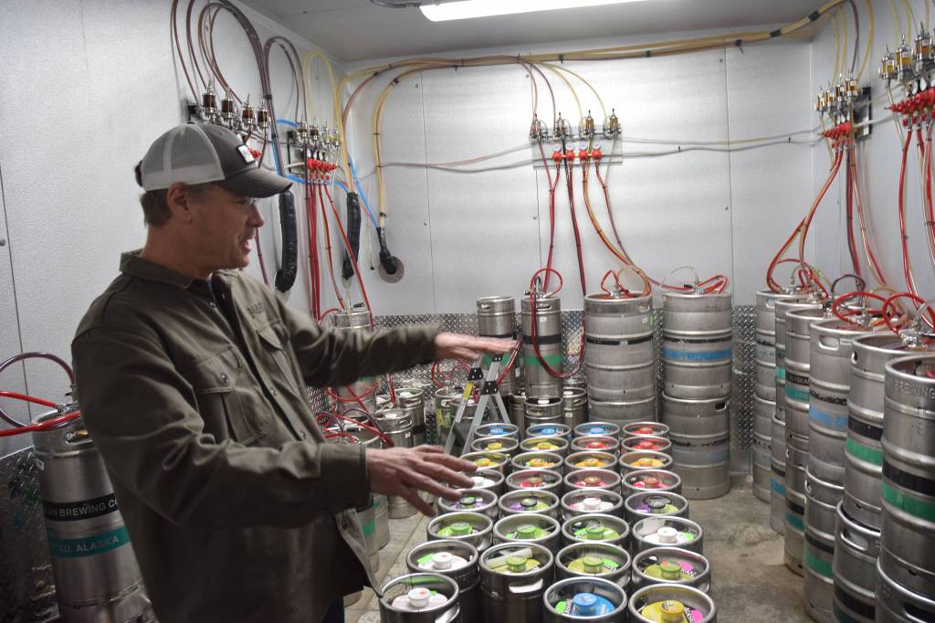 Alaskan Brewing Co.s Andy Kline shows off a new walk-in refrigerator the brewery is using for its new taproom, which opened Saturday. (Kevin Gullufsen | Juneau Empire)