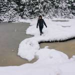 Claire Helgeson attempts to cross between two snow covered ponds. (Gabe Donohoe | For the Juneau Empire)