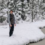 Ian McGonegal approaches edge of pond while snow continues to fall. (Gabe Donohoe | For the Juneau Empire)