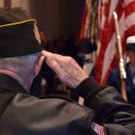 Veteran George Roberts salutes the flag as the U.S. Coast Guard color guard leaves a Centennial Hall ballroom at the conclusion of Veterans Day ceremonies Wednesday, Nov. 11, 2015. (James Brooks | Juneau Empire File)