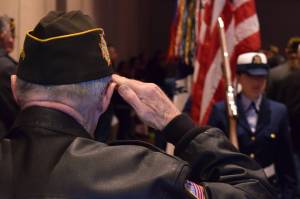 Veteran George Roberts salutes the flag as the U.S. Coast Guard color guard leaves a Centennial Hall ballroom at the conclusion of Veterans Day ceremonies Wednesday, Nov. 11, 2015. (James Brooks | Juneau Empire File)