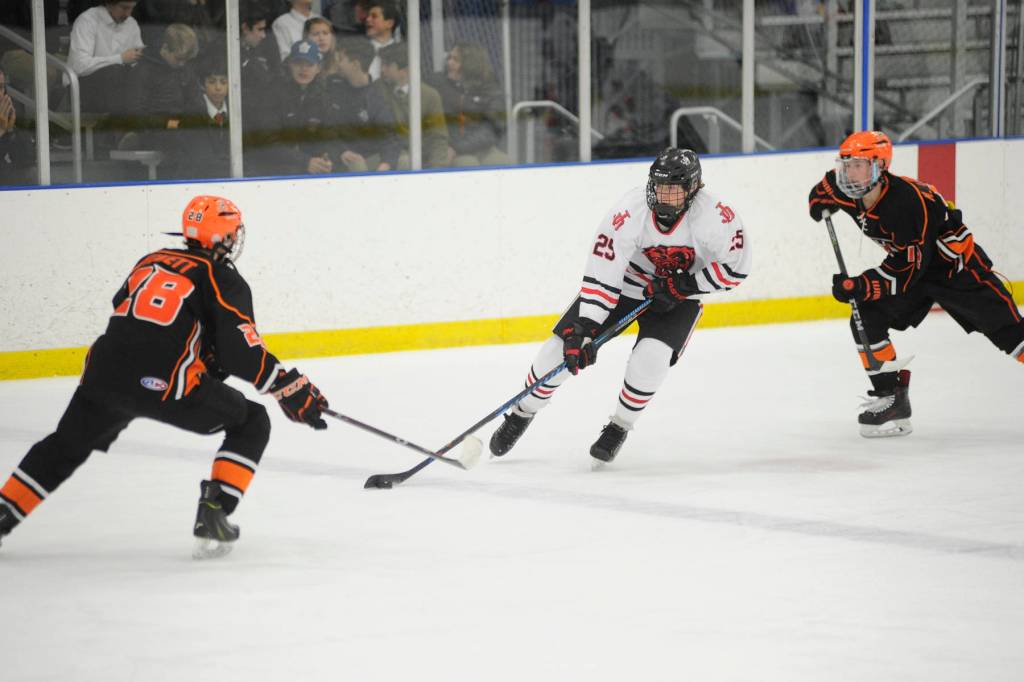 Juneau-Douglas High School senior Owen Squires skates with the puck as West Anchorages Ethan Pickett defends on Saturday at the fourth annual Palmer Showdown Tournament at the MTA Events Center in Palmer. West won 8-1. (Nolin Ainsworth | Juneau Empire)