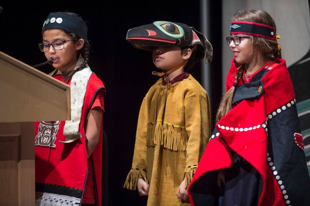 Torianna Johnson, left, Aiden Hood, center, and Marigold Lindoff of the Tlingit Culture Language and Literacy Dance Group from Harborview Elementary School address elders at the Voices of Our Ancestors Language Summit at Centennial Hall on Tuesday, Nov. 13, 2018. (Michael Penn | Juneau Empire)