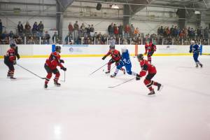 Palmers Zach Nelius is hounded by four Juneau-Douglas players in the second period of the JDHS-Palmer conference game on Saturday, Nov. 17, 2018. JDHS won 9-0. (Nolin Ainsworth | Juneau Empire)
