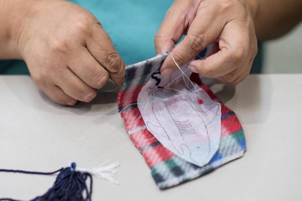 Cecelia Friberg-Rodriguez works on beading a shark pendant during the Celebrating Our Ways of Life for Native American Heritage Month at the Elizabeth Peratrovich Hall on Friday, Nov. 16, 2018. (Michael Penn | Juneau Empire)