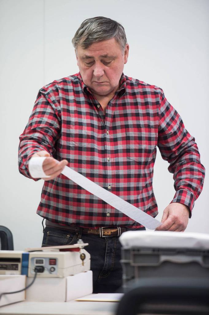Regional Accu-Vote board member Mel Personett looks at a tally of questioned ballots from a Southeast district at the State of Alaska Election Office in the Mendenhall Mall Annex on Tuesday, Nov. 13, 2018. (Michael Penn | Juneau Empire)