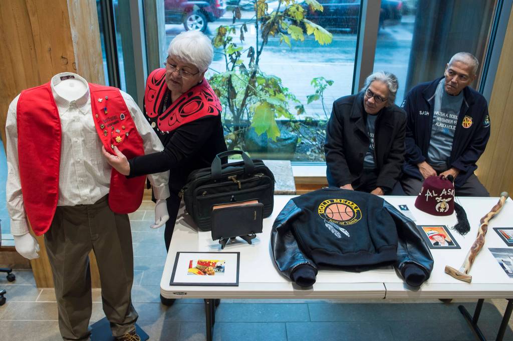 Janet Burke talks about some of her fathers things on display at the Walter Soboleff Center as her brothers, Walter Jr., center, and Sasha, watch on Wednesday, Nov. 14, 2018. Nov. 14 was named Dr. Walter Soboleff Day by the Alaska Legislature in 2014. (Michael Penn | Juneau Empire)