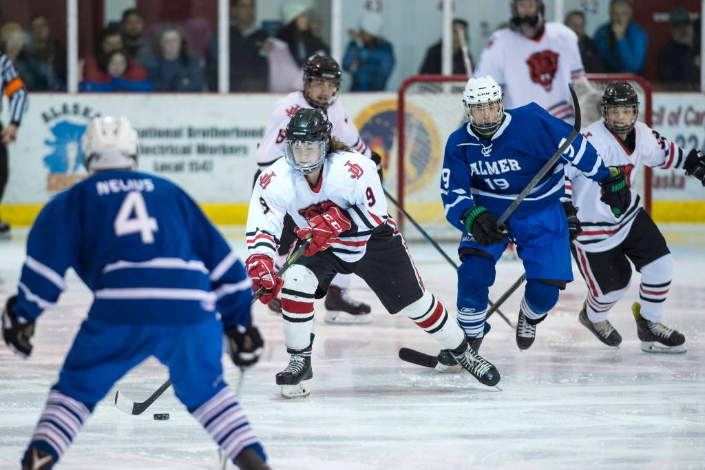 Juneau-Douglas Chance Thrinsky pushes the puck up the ice between Palmers Alex Nelius, left, and Easton Armstrong on Friday, Nov. 16, 2018. (Michael Penn | Juneau Empire