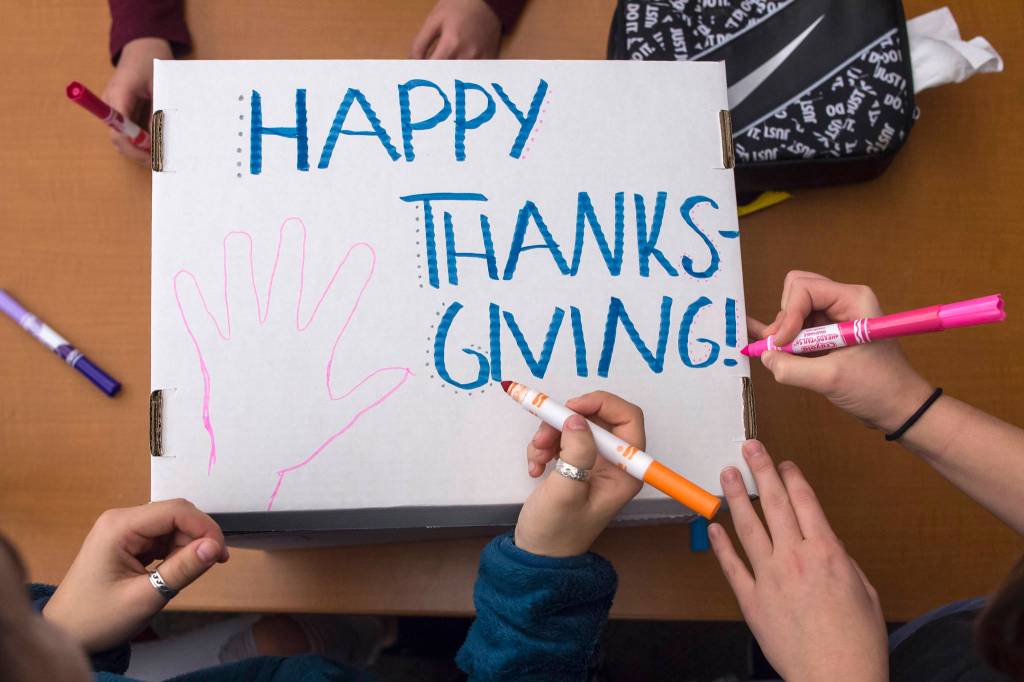 Juneau-Douglas High School student decorate a Thanksgiving dinner box full of food to be donated to AWARE and The Glory Hall on Tuesday, Nov. 20, 2018. (Michael Penn | Juneau Empire)