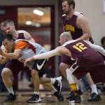 Angoons Curtis Lane passes away from Klukwans Michael Ganey and Jason Shull in the C bracket final at the Juneau Lions Gold Medal Basketball Tournament at Juneau-Douglas High School on Saturday, March 24, 2018. (Michael Penn | Juneau Empire File)