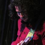 Avery Stewart focuses on an improvised composition during the Woosh Kinaadeiyí Poetry Slam, Oct. 20. Stewart often plays guitar with local bands, but he also use a variety of pedals to make a rhythm section of his own playing over which he can play lead guitar. (Ben Hohenstatt | Capital City Weekly)