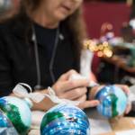 Cindy Wortman-Ziel hand paints Christmas ornaments at the Public Market in Centennial Hall on Friday, Nov. 23, 2018. (Michael Penn | Juneau Empire)