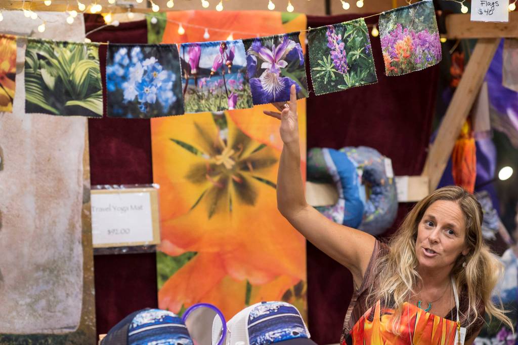 Mandy Ramsey of Soul Happy Art shows her photo prayer flags at the Public Market in Centennial Hall on Friday, Nov. 23, 2018. (Michael Penn | Juneau Empire)