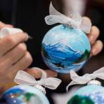 Cindy Wortman-Ziel hand paints Christmas ornaments at the Public Market in Centennial Hall on Friday, Nov. 23, 2018. (Michael Penn | Juneau Empire)
