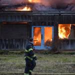 A Capital City Fire/Rescue firefighter walks past the backside of the Thane Ore House during a live fire training exercise on Saturday, Nov. 24, 2018. (Nolin Ainsworth | Juneau Empire)