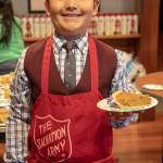 A young volunteer named Austin poses with a slice of pie at the Salvation Armys annual Thanksgiving dinner. (Courtesy Photo | Salvation Army)
