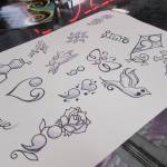 While many customers came in with their own designs for a suicide prevention special event at Taku Tattoo, Friday, Nov. 30, 2018, Salty Jack Reed Jr. came prepared with some designs. (Ben Hohenstatt | Capital City Weekly)