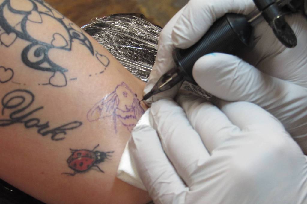 Genevieve McLaughlin received a bumblebee tattoo from Taku Tattoo owner Mario Singh Friday, Nov. 30. McLaughlin said the bee represented community and personal power. (Ben Hohenstatt | Capital City Weekly)