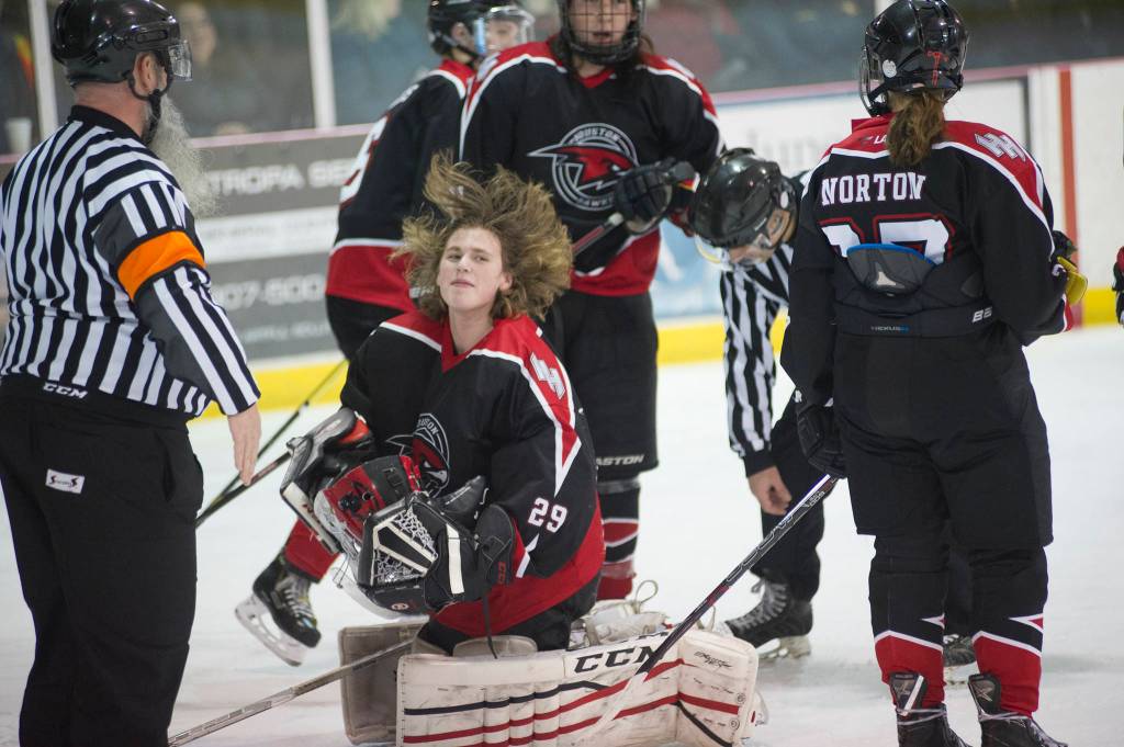 Houston goaltender Josh Smolden adjusts his hair before putting his helmet back on after it came off from a fall to the ice. (Nolin Ainsworth | Juneau Empire)