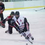 Juneau-Douglas Ethan Welch controls the puck against Houston at the Treadwell Arena on Saturday. (Nolin Ainsworth | Juneau Empire)