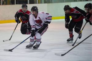 Juneau-Douglas Cameron Smith is chased by Houstons Blake Rogers, left, and Riley Scott in the first period at the Treadwell Arena on Saturday. (Nolin Ainsworth | Juneau Empire)