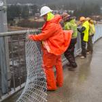 A crew from the Department of Transportation and Public Facilities installs chain-link fencing along the pedestrian walkway over the Douglas Bridge on Monday, Nov. 26, 2018. (Michael Penn | Juneau Empire)