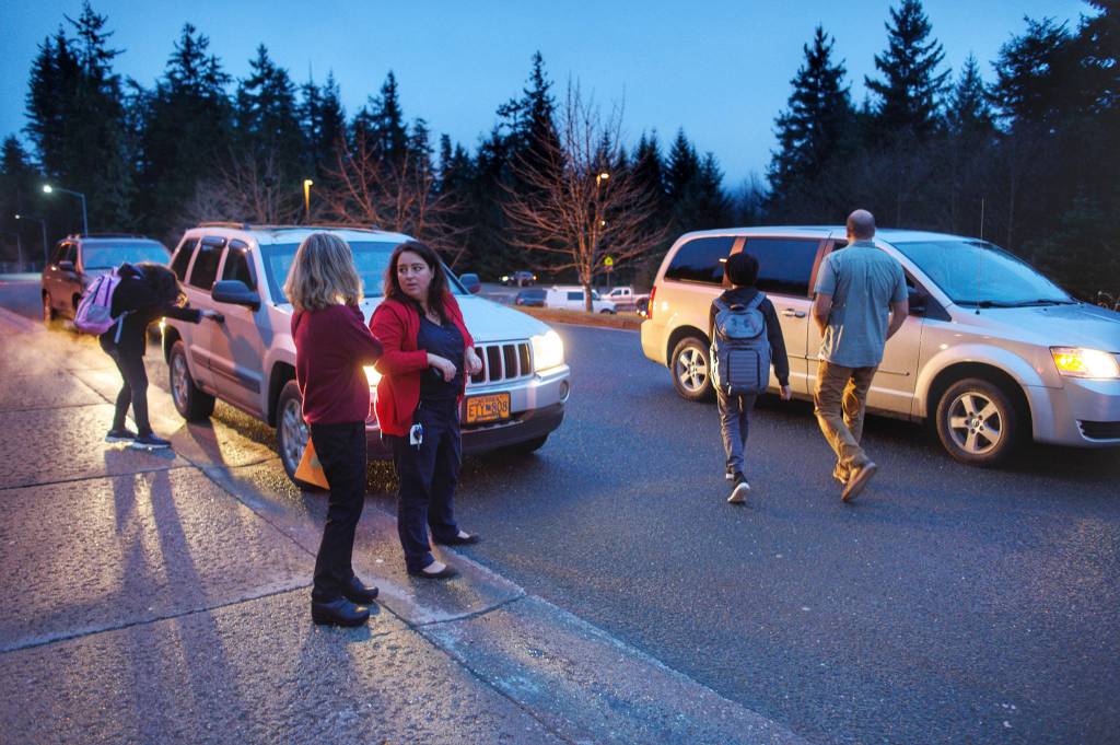Molly Yerkes, principal of Dzantiki Heeni Middle School, center, coordinates as students are escorted to their parents vehicles on Tuesday, Nov. 27, 2018. (Michael Penn | Juneau Empire)