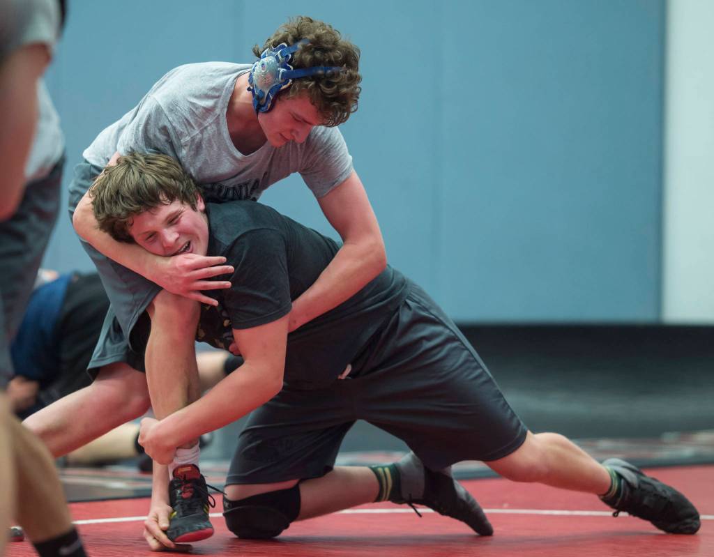 Senior Steven Ireland-Haight, top, workouts against sophomore Camden Erickson during Thunder Mountain High Schools wrestling team practice on Wednesday, Dec. 5, 2018. (Michael Penn | Juneau Empire)