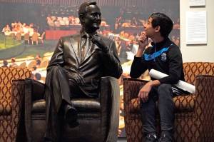 Andrew Lopez, 12, of Midland, Texas, sits next to a statue of George H.W. Bush inside the George H.W. Bush Presidential Library and Museum Saturday, Dec. 1, 2018, in College Station. (David J. Phillip | Associated Press)