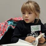 On a Eckerson, 5, works on embroidering a cat onto vintage cloth Saturday, Dec. 8, 2018 during a youth art activity at the Alaska State Library, Archives and Museum. (Ben Hohenstatt | Capital City Weekly)