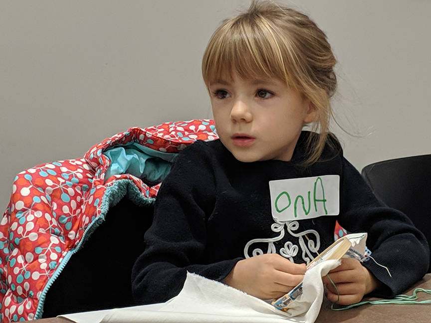 On a Eckerson, 5, works on embroidering a cat onto vintage cloth Saturday, Dec. 8, 2018 during a youth art activity at the Alaska State Library, Archives and Museum. (Ben Hohenstatt | Capital City Weekly)