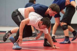 Sophomore Jake Ferster, top, workouts against senior Derek Mason during Thunder Mountain High Schools wrestling team practice on Wednesday, Dec. 5, 2018. (Michael Penn | Juneau Empire File)