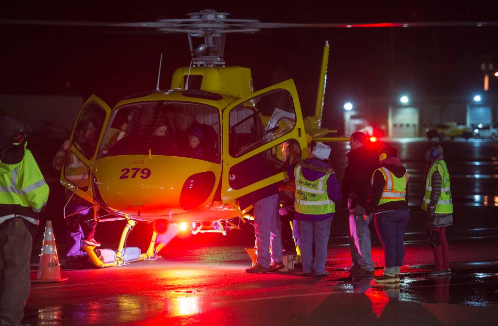 Juneauites board a Coastal Helicopter for the annual Christmas Lights Flights at the Juneau International Airport on Friday, Dec. 15, 2017. Mendenhall Flying Lions put on the event, which is a fundraiser for the American Childrens Tumor Foundation. Petro Marine Services and Coastal Fuel also support the event. (Michael Penn | Juneau Empire File)