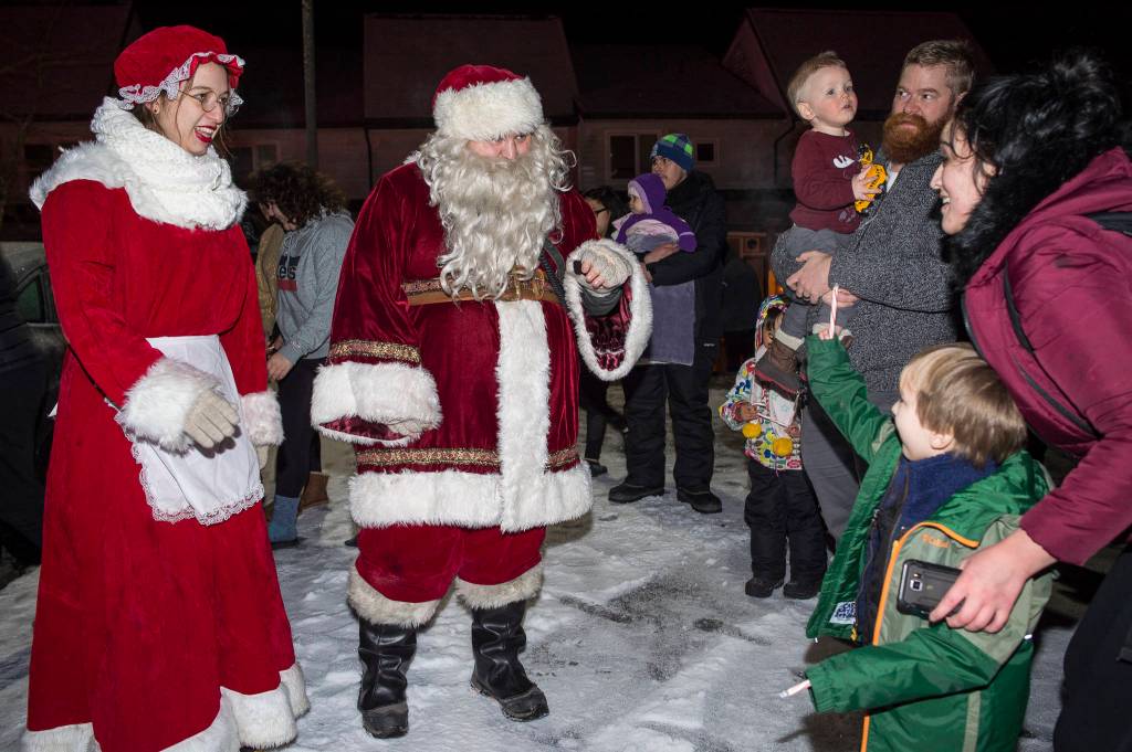 Mr. and Mrs. Claus stop to visit families at Cedar Park during the annual Capital City Fire/Rescue Santa Parade on Friday, Dec. 14, 2018. (Michael Penn | Juneau Empire)