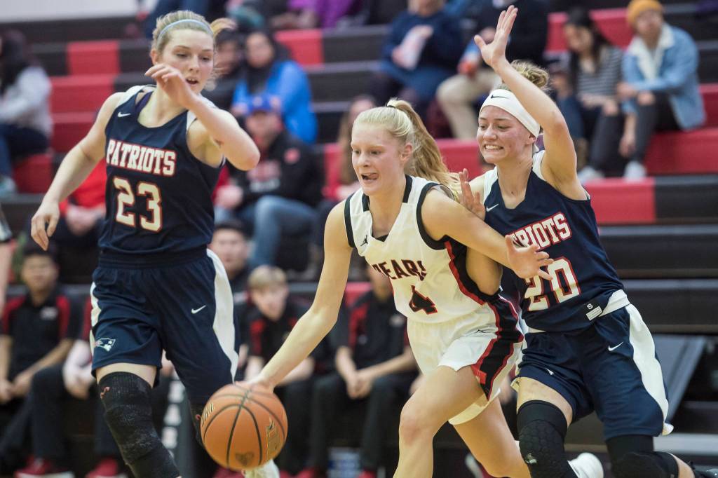Juneau-Douglas Sadie Tuckwood drives between North Poles Megan Grant, right, and Breeauna ORear at JDHS on Friday, Dec. 14, 2018. Juneau-Douglas won 62-32. (Michael Penn | Juneau Empire)