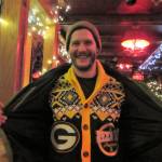 Josh Fortenberry shows off his ugly Packers sweater after dropping off clothing at the Alaskan hotel and Bars ugly sweater party and clothing drive Saturday, Dec. 15, 2018. (Ben Hohenstatt | Capital City Weekly)