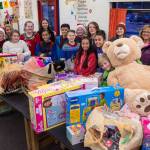 Floyd Dryden Middle School student council members gather around toys collected during a drive for Christmas presents to children in need at FDMS on Monday, Dec. 17, 2018. The toys and gift cards were handed over to the Alaska Department of Health and Social Services Office of Children Services for distribution. (Michael Penn | Juneau Empire)