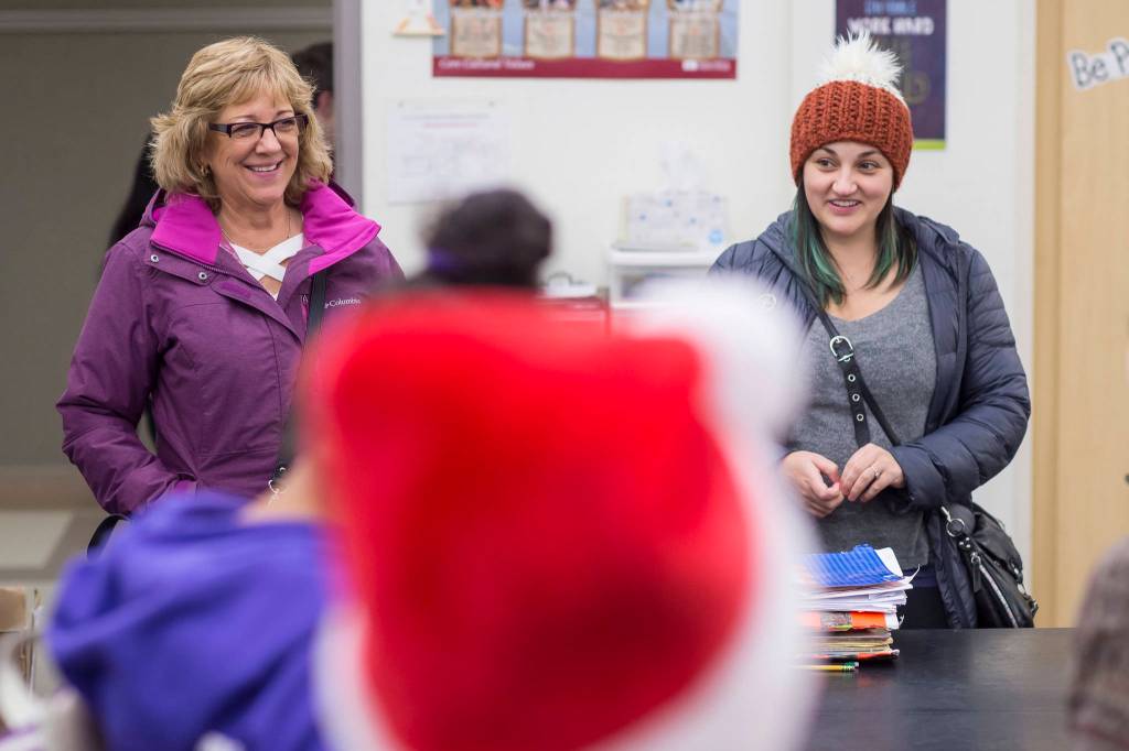 Lynn Logan, left, and Alana Medel, of the Alaska Department of Health and Social Services Office of Children Services, meet with Floyd Dryden Middle School student council members to collect Christmas presents to children in need at FDMS on Monday, Dec. 17, 2018. The student organized a school money and toy drive for the OCS program. (Michael Penn | Juneau Empire)