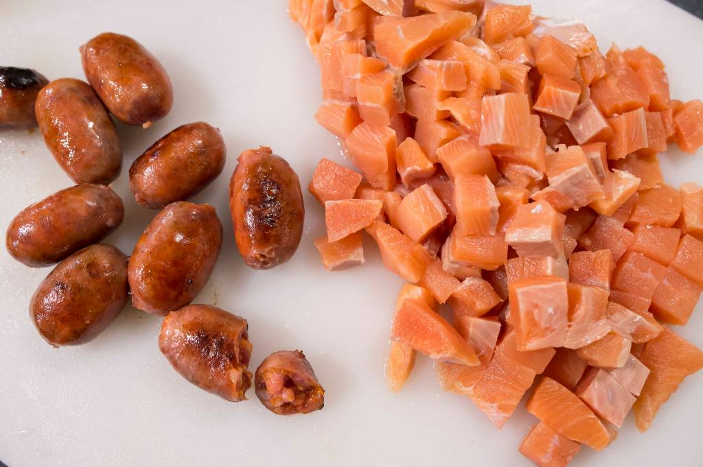 Erin Anais Heist prepares her tomato-based Portuguese fishermans stew with a variety of seafood, spicy sausage, potatoes and smoked paprika in her home kitchen on Friday, Dec. 14, 2018. (Michael Penn | Juneau Empire)
