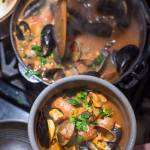 Erin Anais Heist prepares her tomato-based Portuguese fishermans stew with a variety of seafood, spicy sausage, potatoes and smoked paprika in her home kitchen on Friday, Dec. 14, 2018. (Michael Penn | Juneau Empire)
