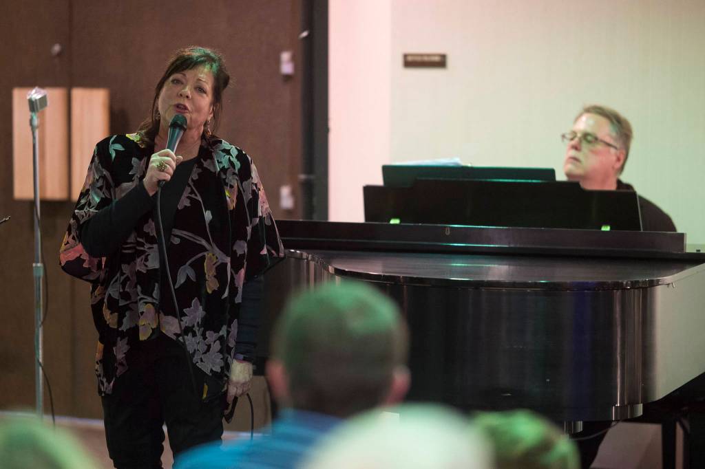 Juneau Cabaret singer Beatrice Caujoille sings for Juneau residents as she is accompanied by Tom Locher during the third annual Holiday Extravaganza at Centennial Hall on Wednesday, Dec. 19, 2018. (Michael Penn | Juneau Empire)