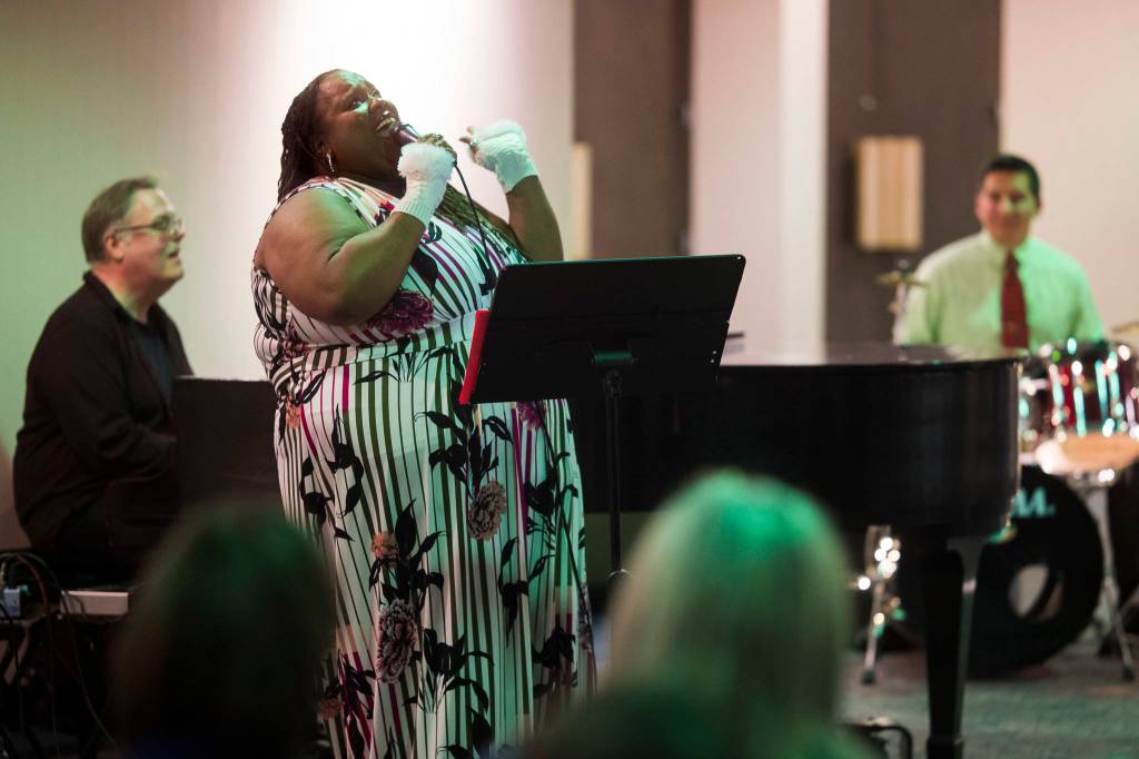 Juneau Cabaret singer Jocelyn Miles sings for Juneau residents as she is accompanied by Tom Locher and David Sheakley-Early during the third annual Holiday Extravaganza at Centennial Hall on Wednesday, Dec. 19, 2018. (Michael Penn | Juneau Empire)