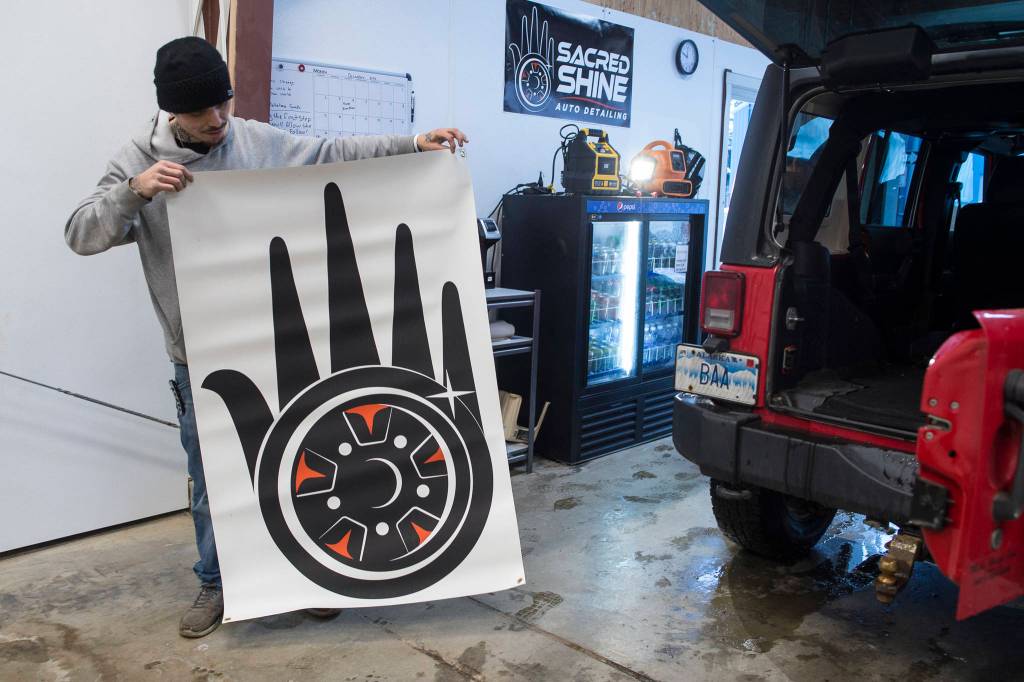 Lead Detailer Calvin Olsen shows the logo developed for a new auto detailing business called Sacred Shine offered by the Central Council of the Tlingit and Haida Indian Tribes of Alaska on Friday, Dec. 21, 2018. The logo was designed by tribal member Miciana Hutcherson. (Michael Penn | Juneau Empire)