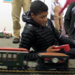 Marion McQueen IV handles the controls for a scale model of the White Pass & Yukon Route Railway train Saturday, Dec. 22, 2018 at Juneau-Douglas City Museum. (Ben Hohenstatt | Capital City Weekly)