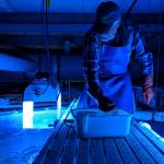 Rich Mattson prepares to deliver a handful of food to the roughly 70 occupants of the large aquarium at the uglas Island Pink and Chums Ladd Macaulay Visitor Center on Dec. 24, 2018. Before tossing food in, Mattson rings a metal pipe to let the fish know its dinner time. (Ben Hohenstatt | Capital City Weekly)